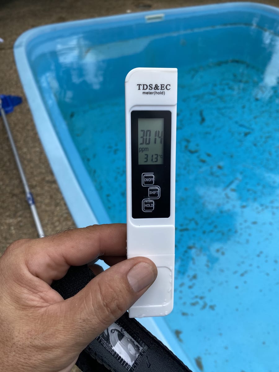 Pen-style pool water test in hand during a Townsville pool consultation
