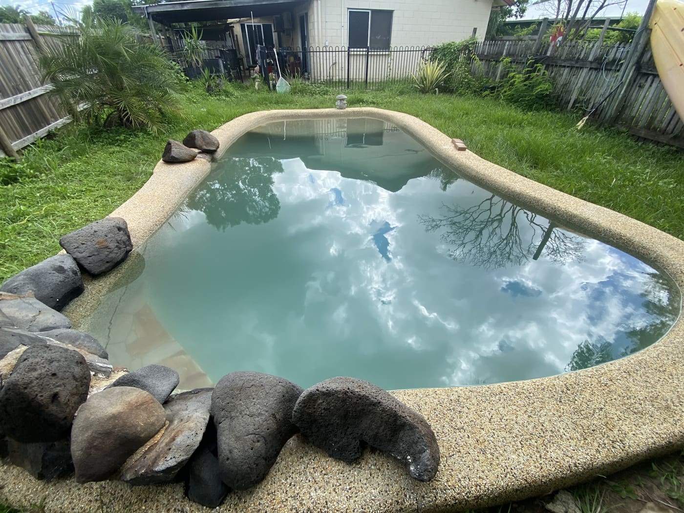 Backyard kidney pool with cloud reflections, freshly serviced in Townsville